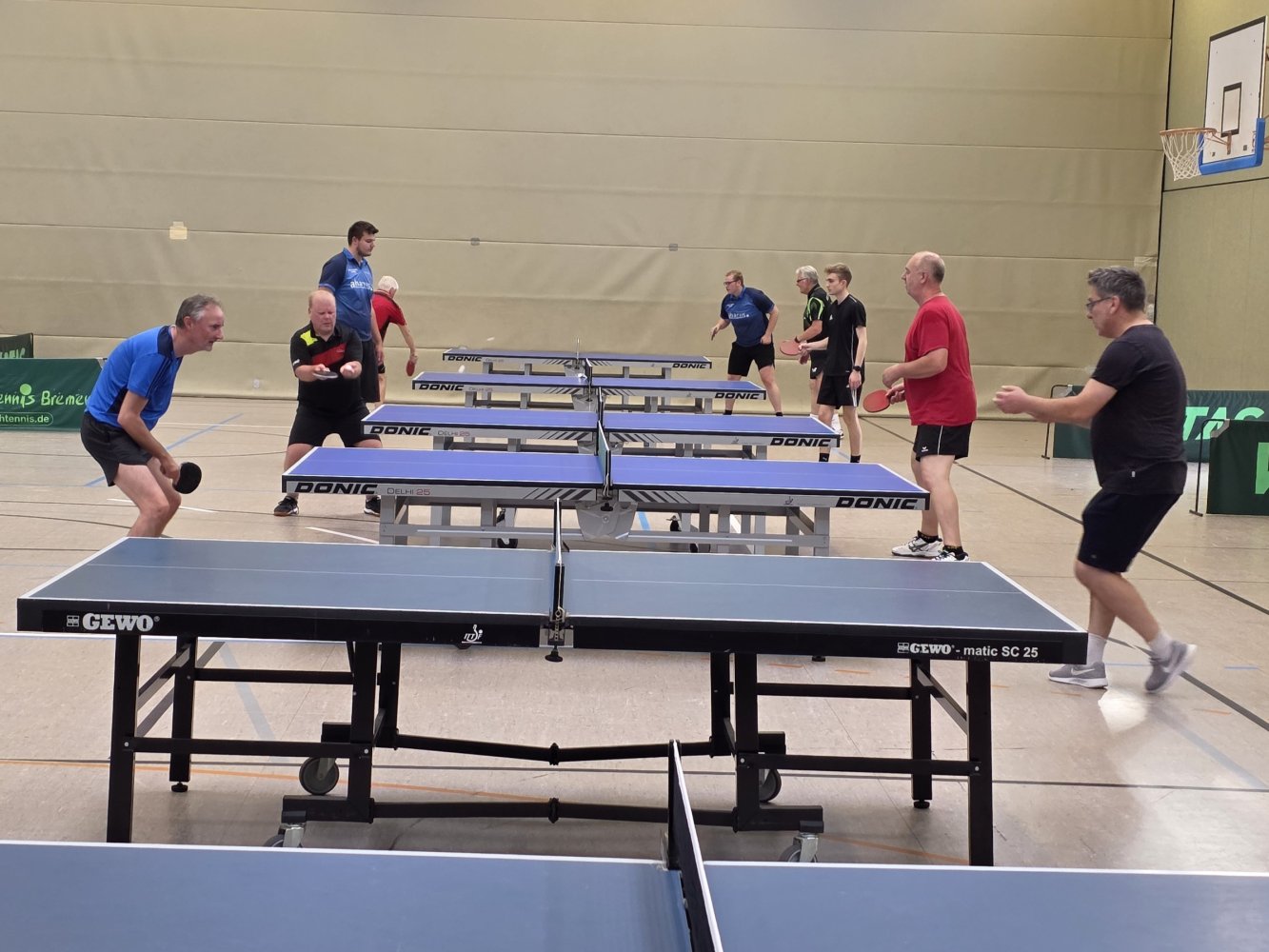 Reihe von Tischtennis-Tischen an denen gespielt wird