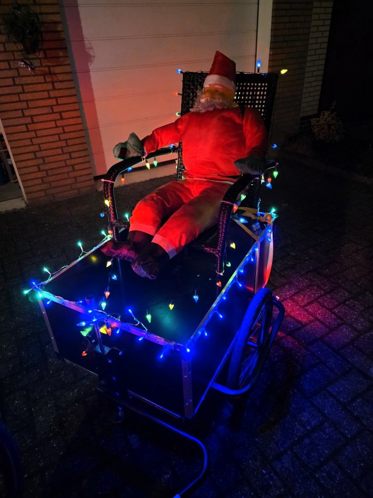 Stephan's Weihnachtsmobil: Ein weihnachtlich dekorierter und beleuchteter Fahrradanhänger mit sitzender Weihnachtsmann-Puppe