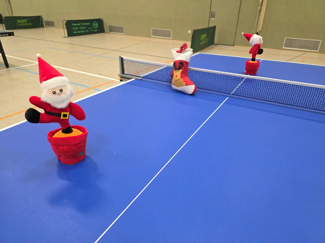 Tischtennis-Tisch mit Weihnachtsmännern und Stiefeln