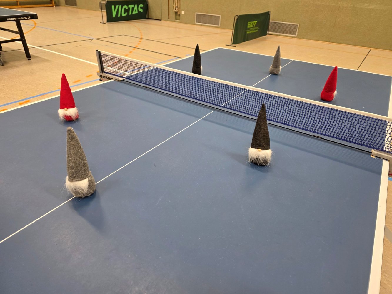 Tischtennis-Tisch mit Weihnachtswichteln, die spitze Hüte tragen